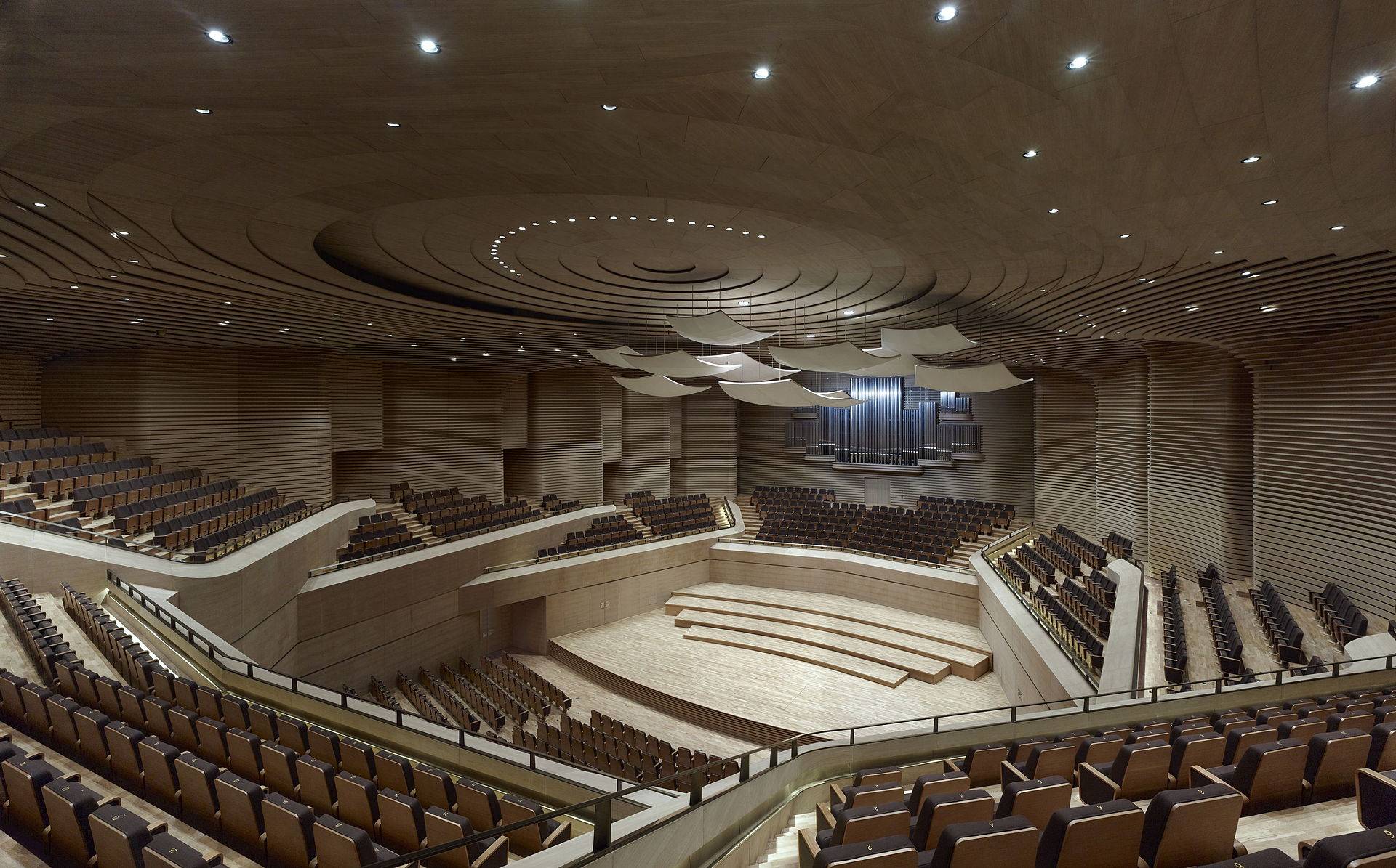 A concert hall from the balcony, tiers of seats curving round the stage