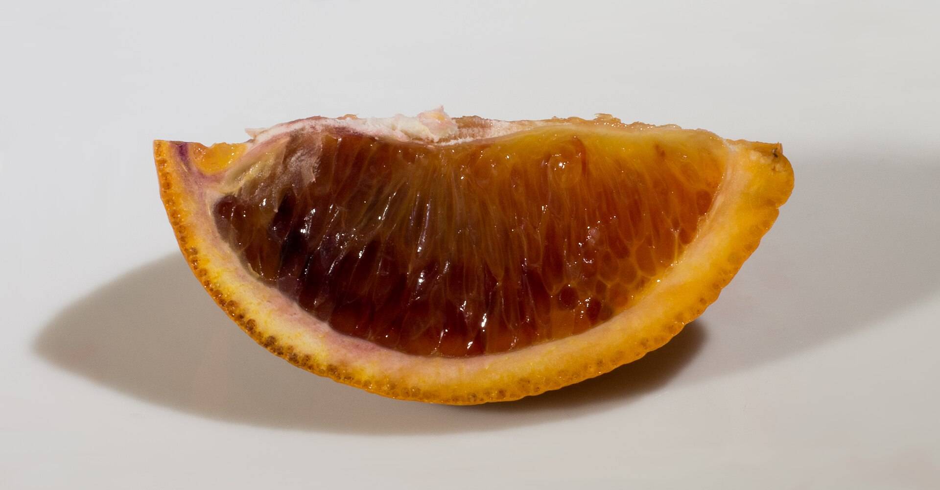 A wedge of blood orange, its flesh deep red