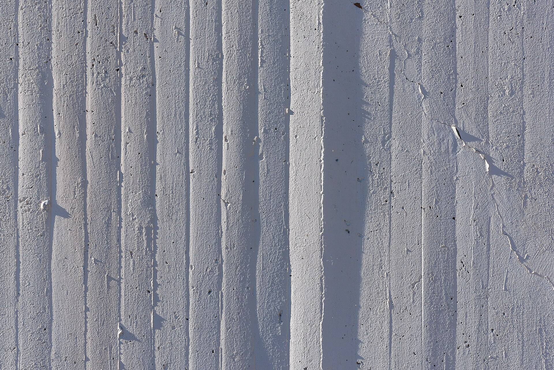 A concrete wall marked by the boards it was cast against