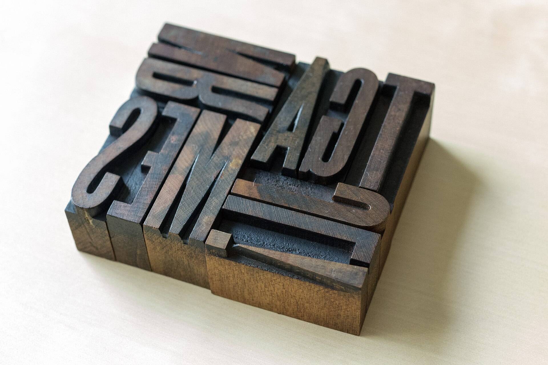A block of old wooden letterpress type, set in reverse