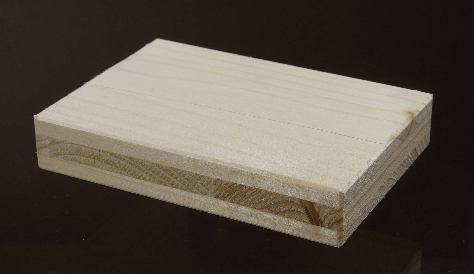 The cut edge of a three-layer spruce board, its layers running across